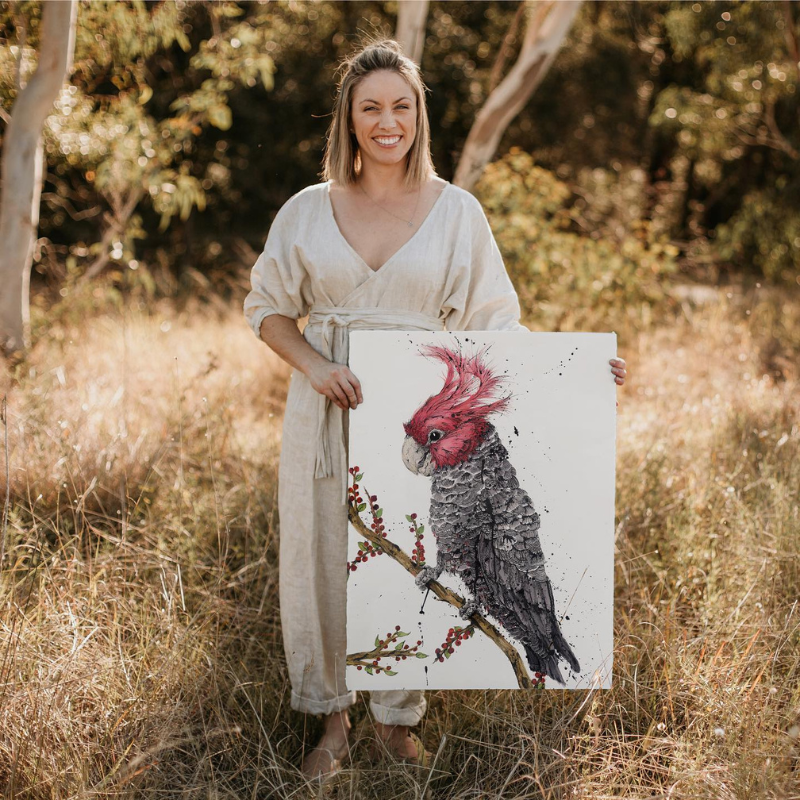 Handmade Ambassador Shannon Dwyer holding an artwork of a gala in the bush.