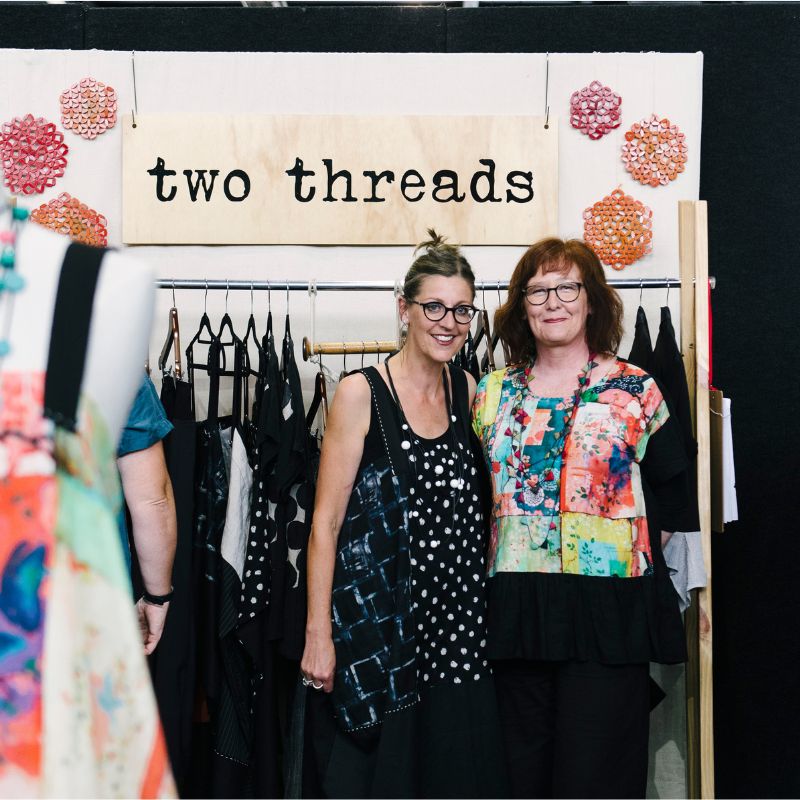 The two ladies from Two Threads standing at their clothing stall